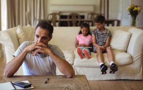 dad sitting with kids looking thoughtful, he has lost his job